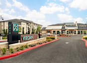Thumbnail 8 of 25 - Elegant community entrance with contemporary design, manicured grounds, and a convenient drive-up arrival experience.