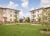 Thumbnail 16 of 25 - Beautiful apartment community featuring spacious green spaces, modern architecture, and thoughtfully landscaped grounds.