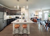 Thumbnail 7 of 25 - Modern open-concept apartment featuring a spacious kitchen with a large island, stainless steel appliances, and stylish finishes.