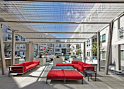 Thumbnail 16 of 28 - Sundeck with Shaded Lounge Seating at Apartments for Rent Oak Lawn Texas