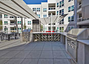 Thumbnail 17 of 28 - Outdoor Kitchen and BBQs at Apartments near Medical District Dallas