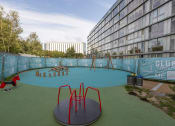 Thumbnail 3 of 5 - a playground at an apartment building with a swimming pool