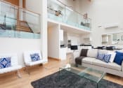 Thumbnail 1 of 5 - a living room with a couch and a glass table
