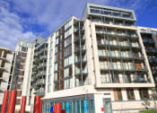 Thumbnail 4 of 5 - a large apartment building with many balconies and a blue sky