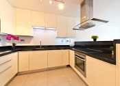 Thumbnail 2 of 5 - a kitchen with black counter tops and white cabinets