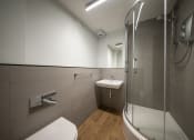 Thumbnail 3 of 8 - a bathroom with a shower and a sink and a toilet