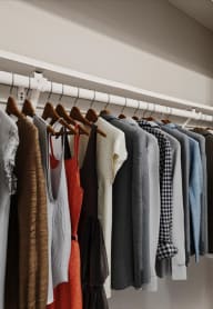 a closet filled with clothes hanging on a rack