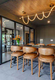 A modern dining area with a wooden table and chairs.