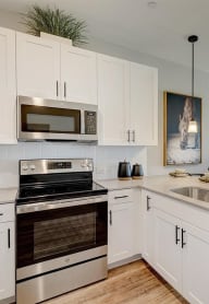 a kitchen with white cabinets and stainless steel appliances