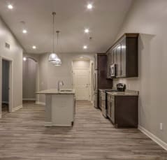 a kitchen and living room with a hardwood floor