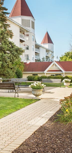 a courtyard with benches and trees and a building in the background