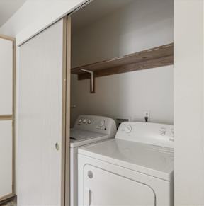 A white washing machine and dryer in a small laundry room.