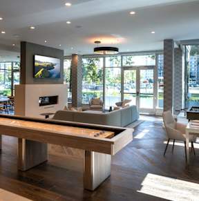 a living room with a pool table and a dining room