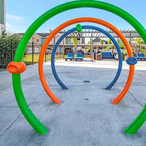 A playground with a green, orange, and blue structure.