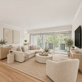 A living room with a grey couch, a coffee table, and a painting on the wall.