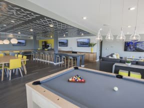 a games room with a pool table and chairs