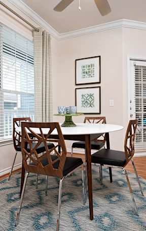 A dining room with a table and chairs.
