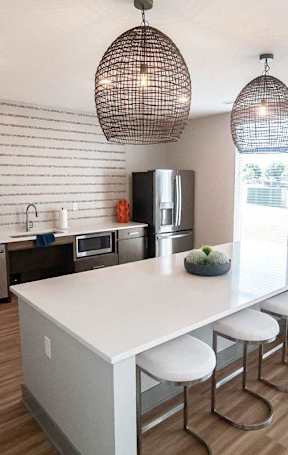 A kitchen with a white counter and a white fridge.