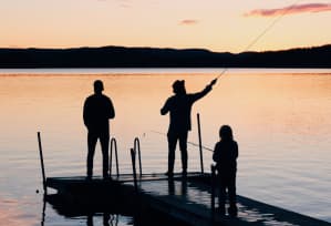 people fishing on a dock at the lake at sunset at Lake Johnson Mews Apartments, PRG Real Estate Management, Raleigh, 27606