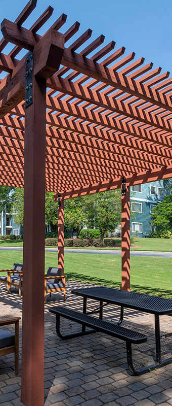 a patio with a picnic table and chairs under a pergola