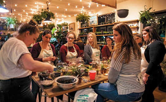 A group of people are gathered around a table with bowls of food.