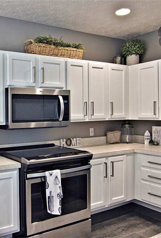A kitchen with white cabinets and a black stove top.