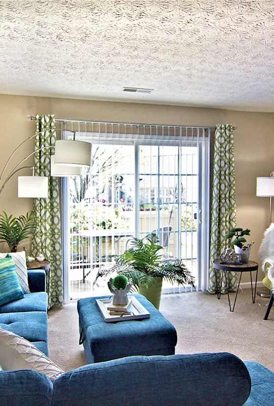 A living room with a blue couch and a green chair.