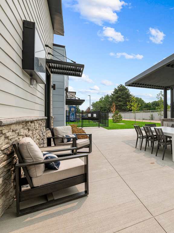 A patio with a table and chairs under a roof.