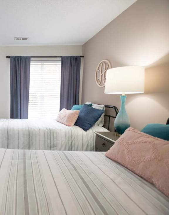 A bedroom with a bed, dresser, and window.