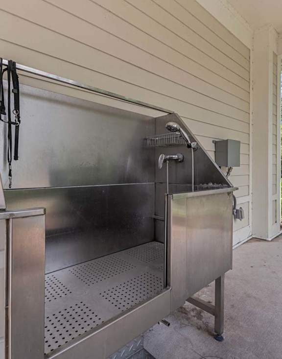 A stainless steel outdoor grill is attached to a house.