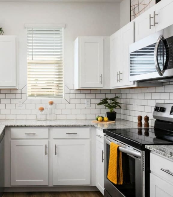 a white kitchen with marble counter tops and white cabinets