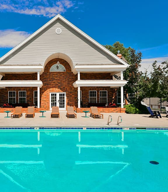 A house with a pool in front of it.