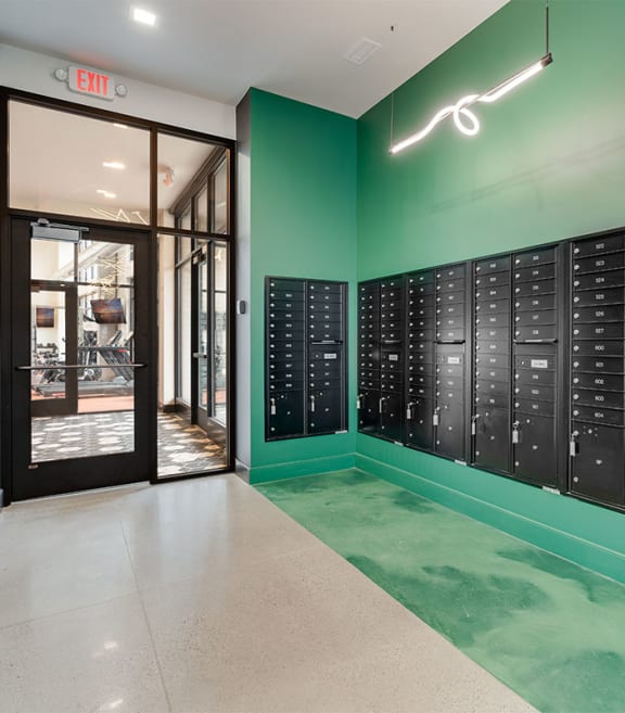 a lockers room with a green wall and a glass door