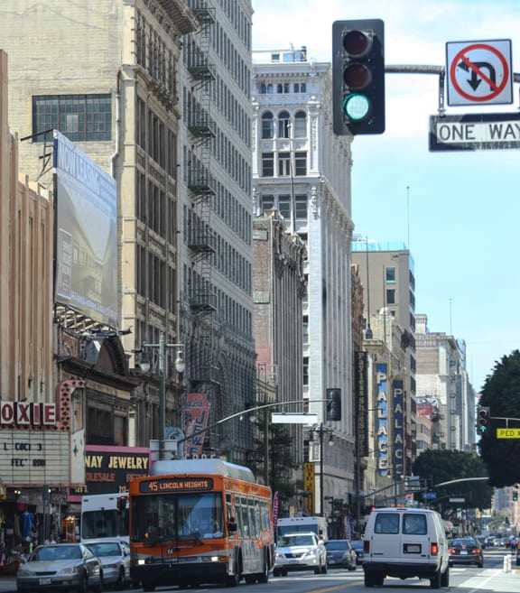 a busy city street with cars and buses and a traffic light