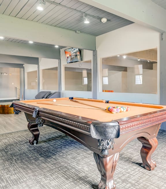 A pool table in a room with a grey carpet.