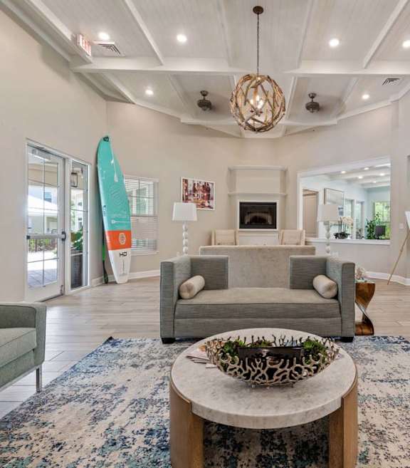 A living room with a grey sofa, a coffee table, and a fireplace.