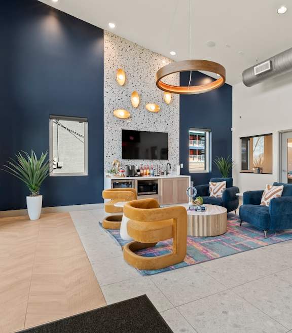 The Canvas Apartments Nashville leasing office with complimentary coffee bar and seating area with navy blue and gold chairs.