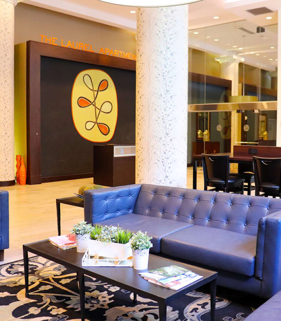 the lobby of a hotel with blue couches and tables at The Laurel Apartments, Saint Louis, 63101