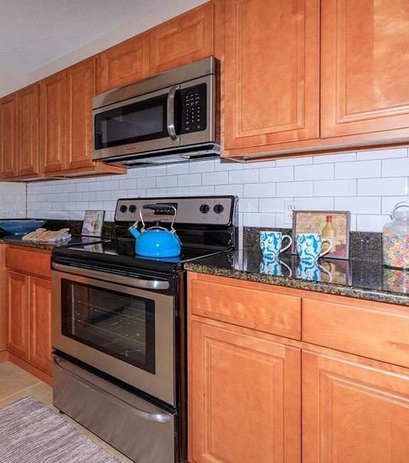 A kitchen with wooden cabinets and black countertops.
