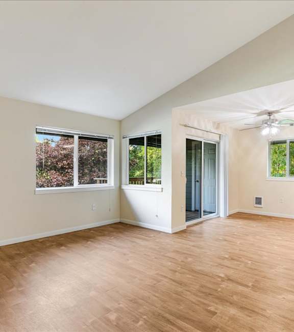 A room with wooden flooring and a ceiling fan.
