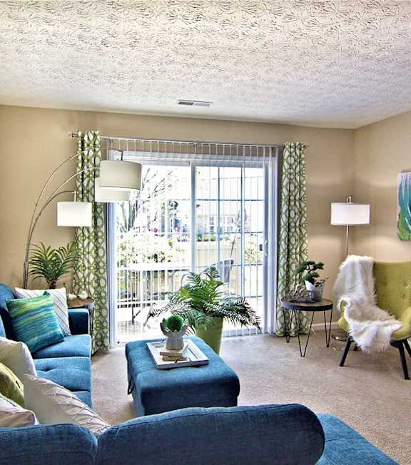 A living room with a blue couch and a green chair.