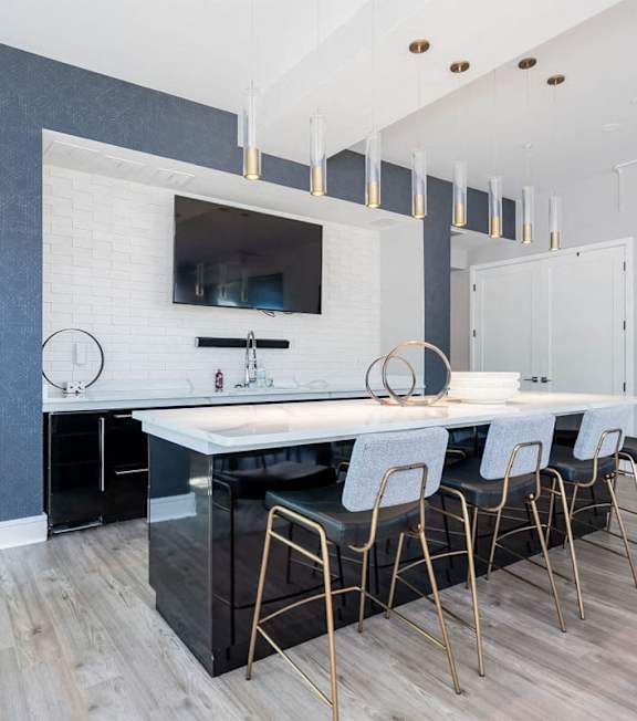 A modern kitchen with a white countertop and black cabinets.