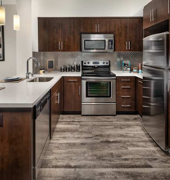 Fusion Encore kitchen with brown accents and stainless steel appliances