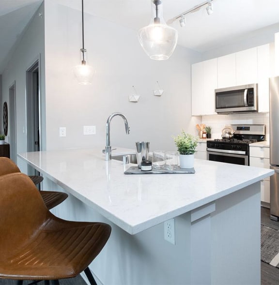 a kitchen with a large island and a stainless steel refrigerator