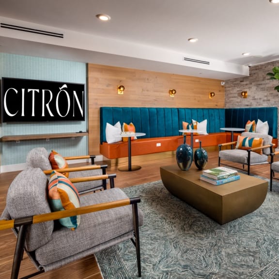 A Citron sign is on a wall above a couch and chairs.