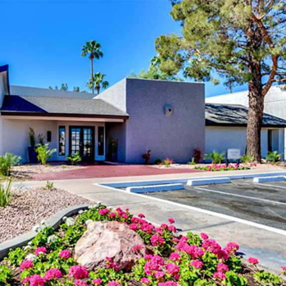 A house with a blue roof and a garden in front.
