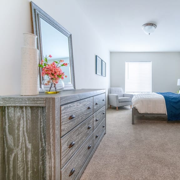 a bedroom with a bed and a dresser and a mirror