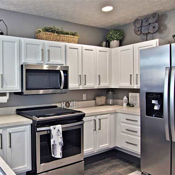 A kitchen with white cabinets and a black stove top.