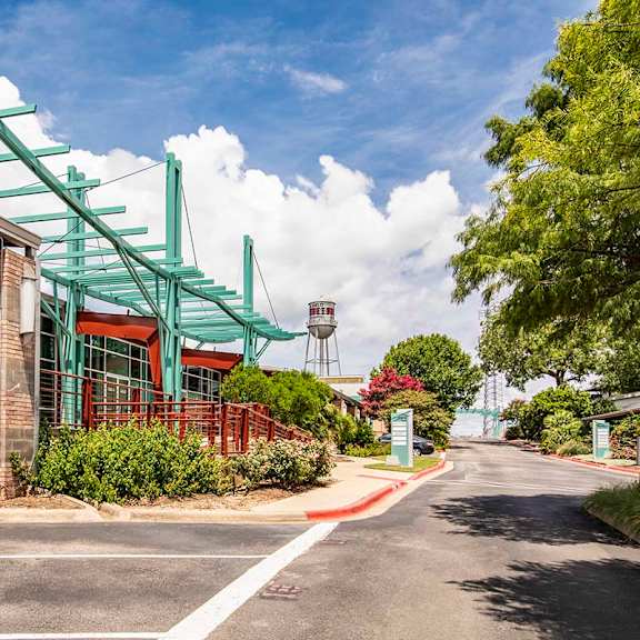 A building with a green awning is on the corner of a street.
