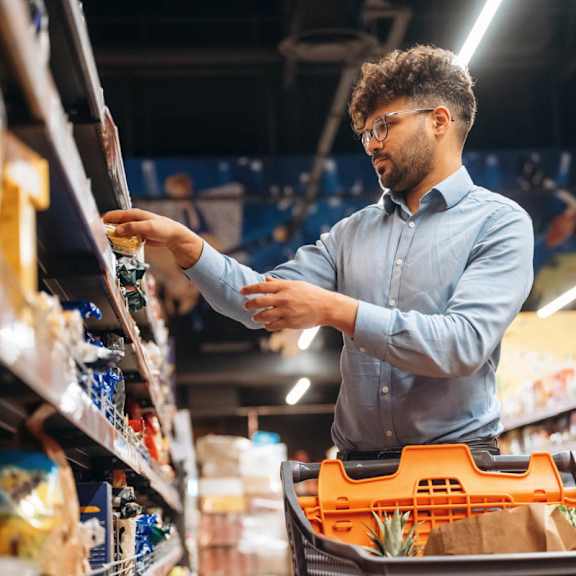 A man is shopping for groceries in a supermarket.